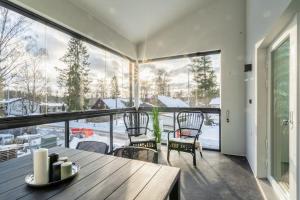 a large balcony with a wooden table and chairs at Kotimaailma - Furnished Apartment in Vantaa with key code in Vantaa
