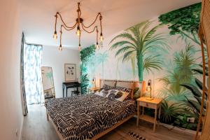 a bedroom with a large mural of palm trees at Urban Jungle in the City Center in Timişoara