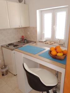 a kitchen with a bowl of oranges on a counter at Apartments Laura Mljet in Sobra