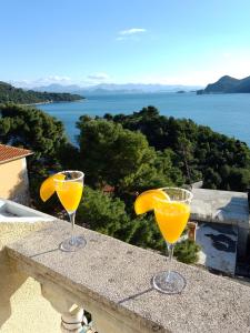 two glasses of orange juice sitting on a ledge at Apartments Laura Mljet in Sobra