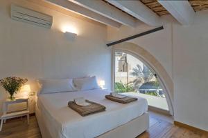 um quarto branco com uma cama grande e uma janela em Villa Pruno - Happy Rentals em Scicli