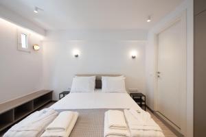 una camera da letto bianca con un letto e asciugamani di Room Garden a Salonicco