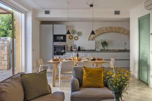 uma sala de estar e cozinha com um sofá e uma mesa em Villa Pruno - Happy Rentals em Scicli