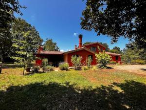 a red house with a yard in front of it at Holiday Home Serrari in Eremo