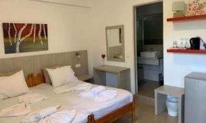 a bedroom with a bed and a sink and a mirror at ERA Studios in Skiathos