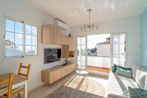 a living room with a couch and a tv at Edf Papillon in Nerja