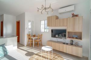 a living room with a tv and a table with chairs at Edf Papillon in Nerja