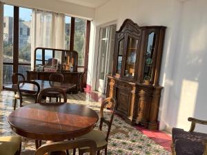 een kamer met een tafel en stoelen en een houten kast bij Villa Jole Faraglioni Acitrezza in Aci Castello