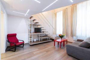 フィレンツェにあるGinori - 2 bedrooms apartment by Mercato Centraleのリビングルーム(ソファ、赤い椅子付)