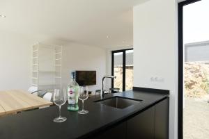 a kitchen with two wine glasses and a sink at Duna Colorada in Lajares