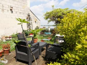 un patio con sedie e piante in giardino di La Halte des Bateliers et des Vignobles a Rochefort-sur-Loire
