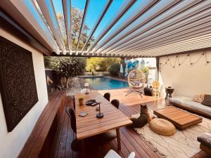une terrasse avec une table et une piscine dans l'établissement Villa Jeanne&Clems, à Mirepoix-sur-Tarn