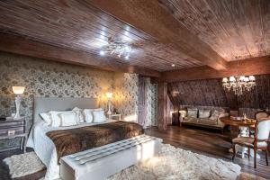 um quarto com uma cama, um sofá e uma mesa em Chateau La Villette em Campos do Jordão