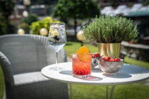 un tavolo con un bicchiere di vino e un cesto di frutta di Manuelina Taste Hotel a Recco