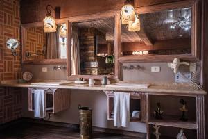 La salle de bains est pourvue de 2 lavabos et d'un miroir. dans l'établissement Chateau La Villette, à Campos do Jordão