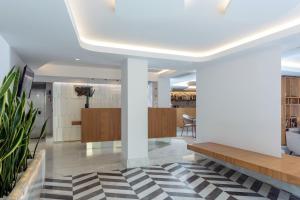 a lobby with white columns and a black and white rug at Iraklion Hotel in Heraklio