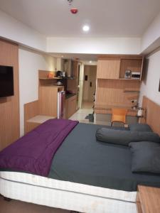 1 Schlafzimmer mit einem großen Bett und einer Küche in der Unterkunft Hani Apartemen Simpang lima in Semarang