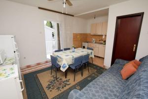 a living room with a table and a kitchen at Apartments Ruzinka in Podaca