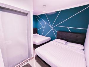 um quarto com 2 camas e uma parede azul em Sea Love Homestay Pulau Ketam em Bagan Teochew