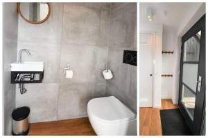 een badkamer met een toilet, een wastafel en een spiegel bij Skylgerduin in Midsland