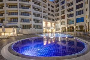 a swimming pool in front of a building at Continental Apartments in Golden Sands