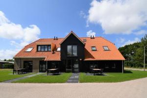 una casa con techo naranja y algunas mesas en Skylgerduin, en Midsland