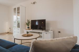 a living room with a blue couch and a tv at Villa Nika in Klimno