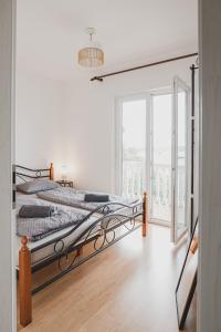 a white bedroom with a bed and a large window at Villa Nika in Klimno