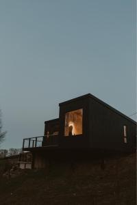 a black house with a window on the side of it at Modern log cabin with hot tub in Newtown