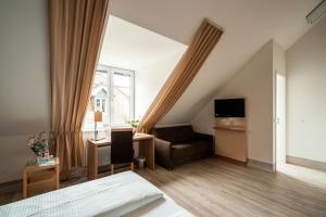 1 dormitorio con cama, sofá y ventana en Weinhotel Wasem, en Ingelheim am Rhein