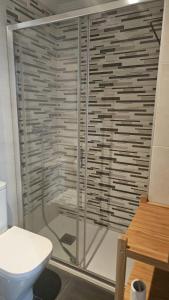 a shower stall in a bathroom with a toilet at Sunshine beach Gijón in Gijón