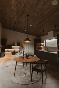 sala de estar con mesa y cocina en Modern log cabin with hot tub, en Newtown