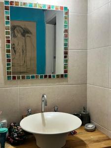 a bathroom with a white sink and a mirror at CasaEstudio in El Chalten