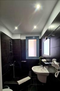 a bathroom with a sink and a toilet and a window at Villa Serafeim in Kymi