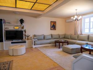 sala de estar con sofá y TV en Oliviade Village, 