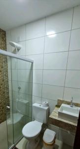 een badkamer met een toilet, een wastafel en een douche bij casa confortável in Camaçari