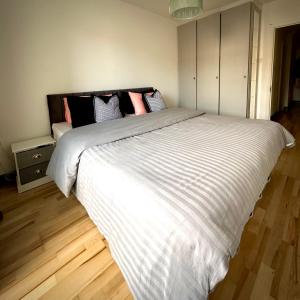 a bedroom with a large white bed with pink pillows at Riverview Apartment in Dublin