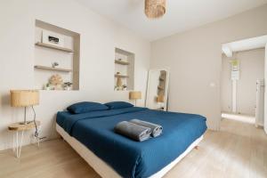 a bedroom with a blue bed and white walls at Luxurious 1 Bedroom Quartier de la Bastille Free Netflix in Paris