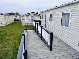 a wooden deck next to a building with a house at Rye Harbour Holiday Park in Rye Harbour