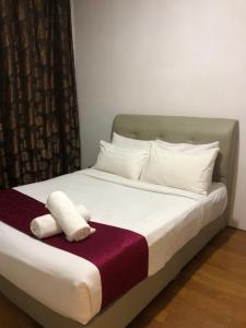 Una cama con una toalla blanca encima. en Vortex Suites KLCC by Luna, en Kuala Lumpur