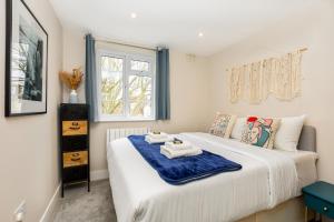 een slaapkamer met een bed met handdoeken erop bij Exquisite 1BR in Chiswick, 3 min to Train Station in Londen