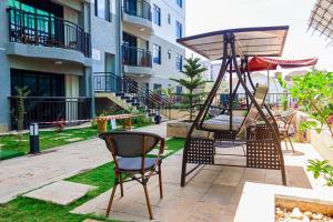 eine Terrasse mit 2 Stühlen und einer Schaukel in der Unterkunft City Haven Accommodation-Two bedroom Apartment in Nairobi