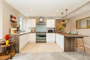 a kitchen with white cabinets and a counter top at Exquisite 1BR in Chiswick, 3 min to Train Station in London