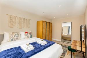 una camera da letto con un grande letto con asciugamani di Exquisite 1BR in Chiswick, 3 min to Train Station a Londra