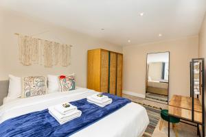 a bedroom with a large bed with towels on it at Exquisite 1BR in Chiswick, 3 min to Train Station in London