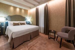 une chambre d'hôtel avec un lit et une chaise dans l'établissement Acca Hotel, à Venise