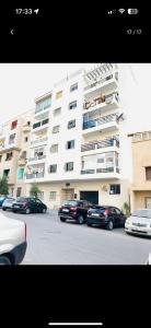 a large apartment building with cars parked in front of it at Appartement Rabat Océan in Rabat
