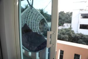 een glazen deur met een stoel in een raam bij Skylight Property in Bangalore