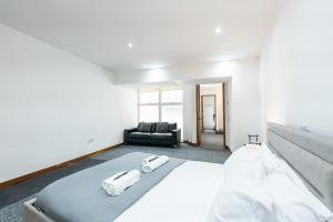 um quarto com uma cama e um sofá preto em Luxury 2 Bedroom Flat in Bell Street em Londres
