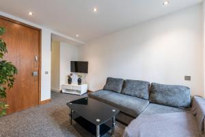 a living room with a couch and a tv at Luxury 2 Bedroom Flat in Bell Street in London